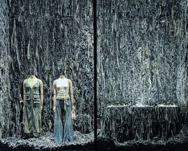 Walls of shredded denim behind two Diesel mannequins
