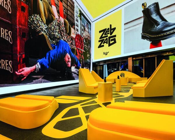 Yellow seating and Dr. Martens screens at The Art of Comfort Experience
