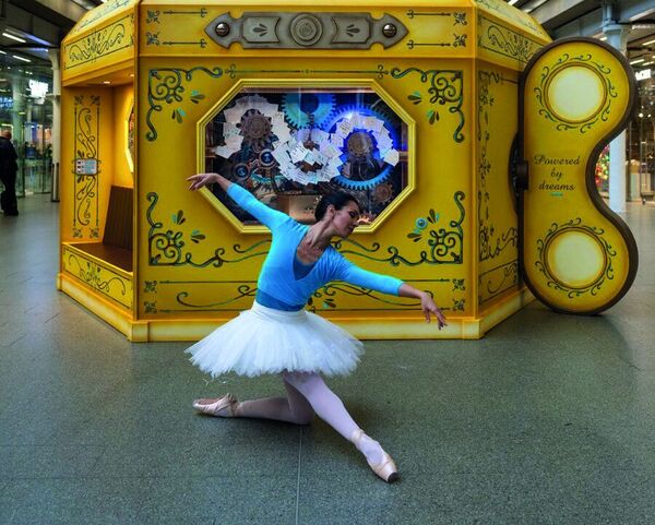 A ballerina dancing in front of the yellow Highspeed pod at St. Pancras International